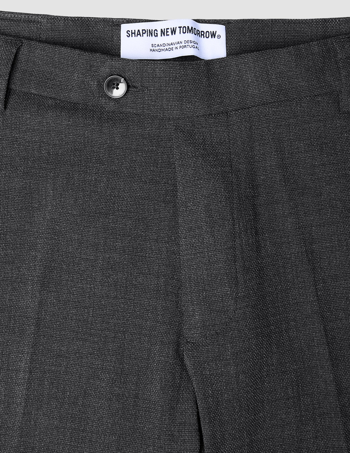 Motion Suit-bukse i Regular-passform, Pepper Grey, i klassisk skandinavisk design med knapp midt foran og hvit merkelapp.